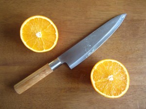 Chef's knife and an orange that has been cut open